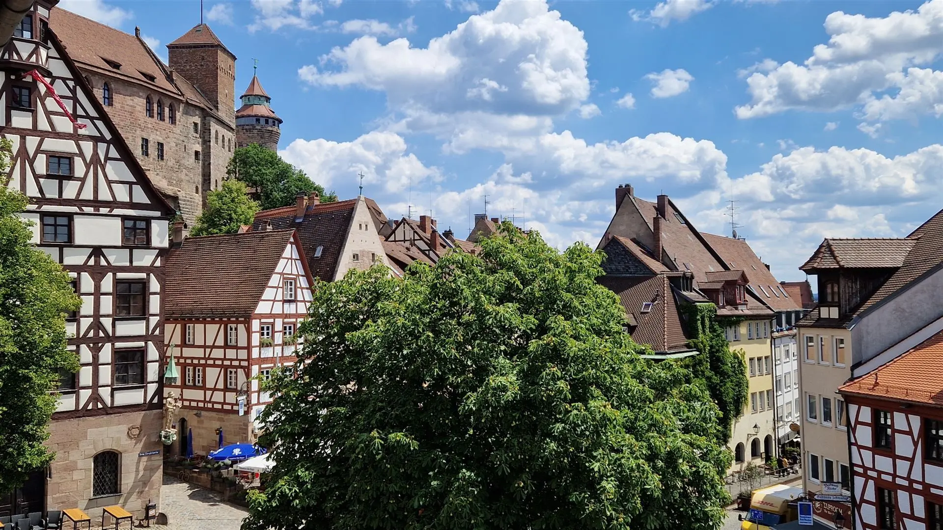 Burg und Fachwerkhäuser unter blauem Himmel